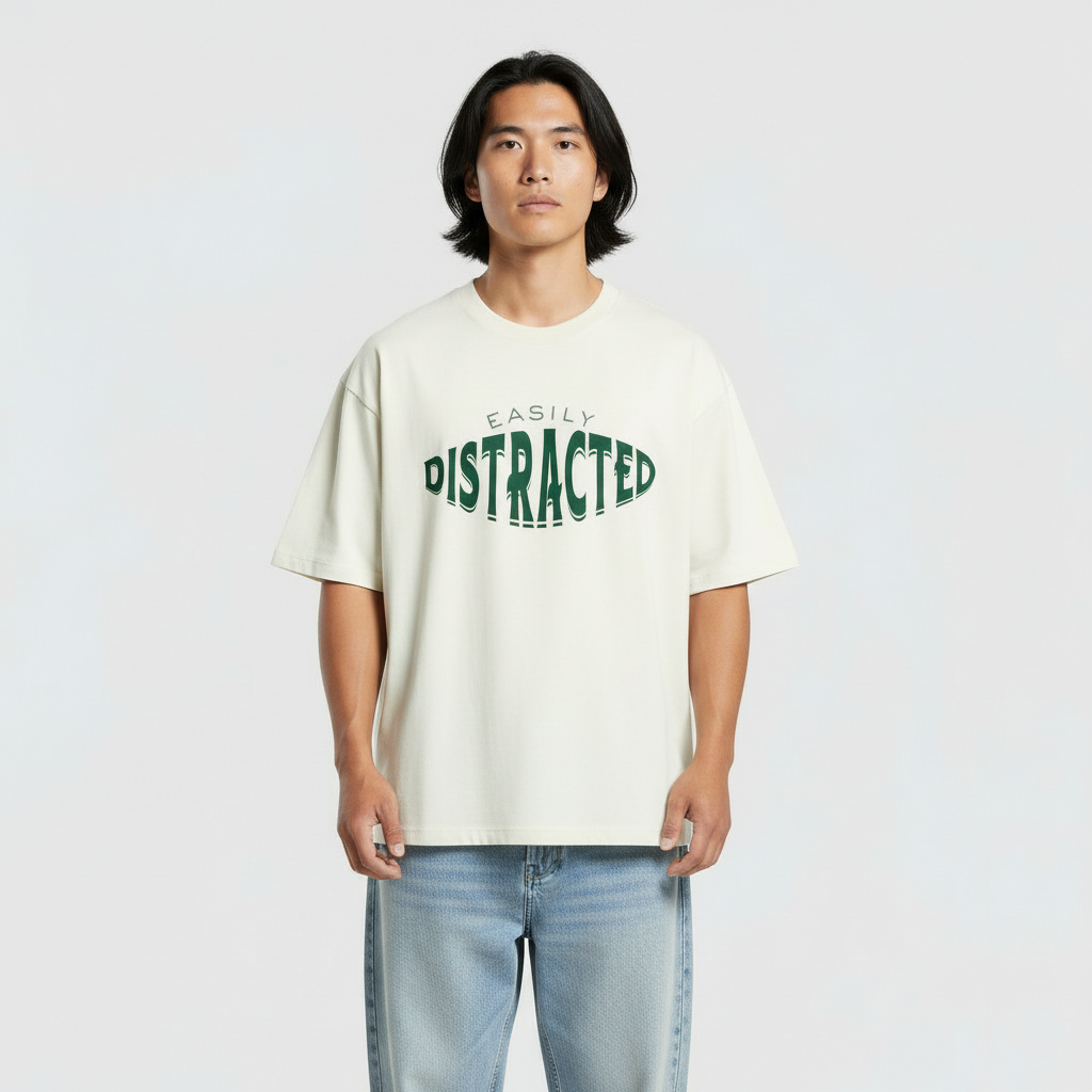 Person wearing a cream t-shirt with green text on a plain background
