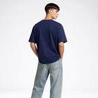 Person wearing a blue t-shirt and light blue jeans on a white background