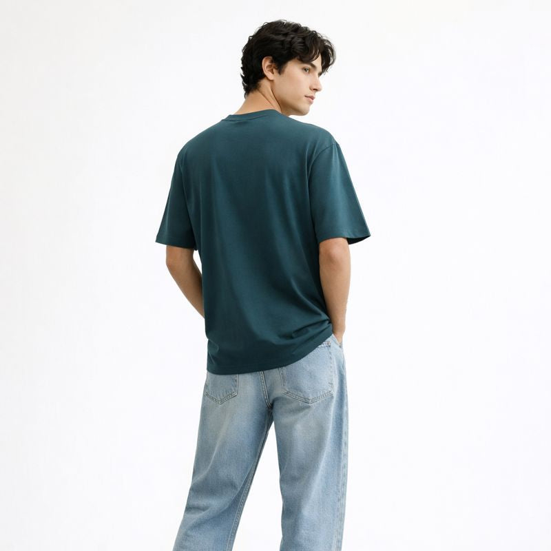 Person wearing a green t-shirt and light blue jeans on a white background