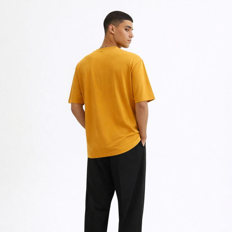 Person wearing a yellow t-shirt and black pants on a white background