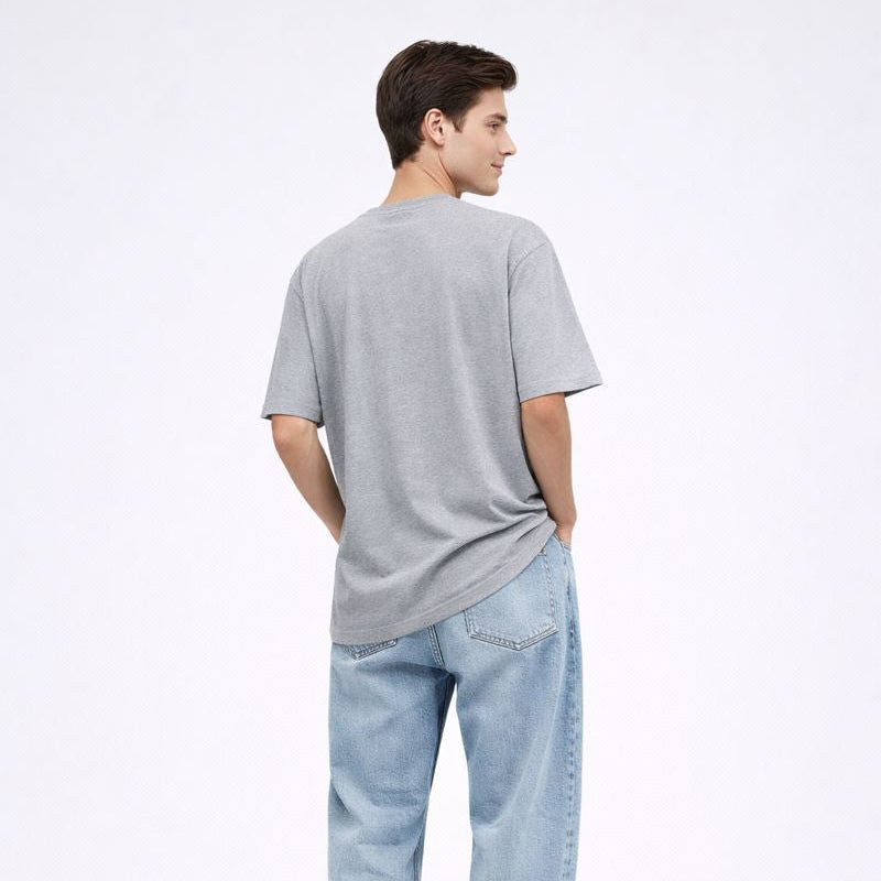 Person wearing a gray t-shirt and light blue jeans on a white background